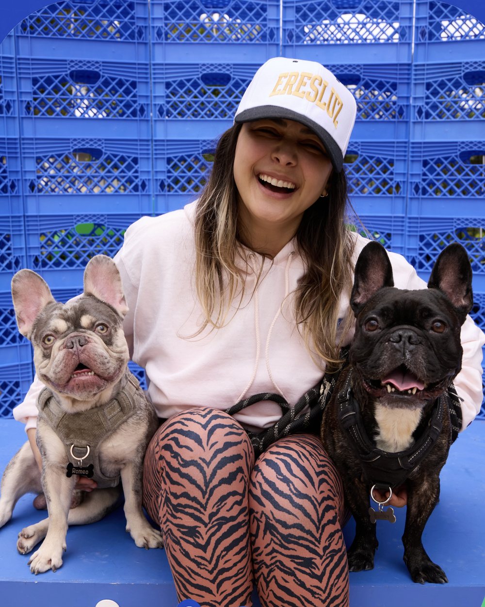 Cata riéndose entre Romeo, un bulldog francés merle, y Bentley, un bulldog francés atigrado negro